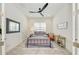 Bedroom with a modern ceiling fan, tiled floor, and stylish decor creating a comfortable atmosphere at 15525 Corona Del Mar Dr, Wimauma, FL 33598