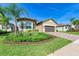 Beautiful single-Gathering home showcasing a well-maintained lawn and lush landscaping at 15525 Corona Del Mar Dr, Wimauma, FL 33598
