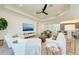 Spacious living area featuring white sofas, a ceiling fan, and a mounted television at 15525 Corona Del Mar Dr, Wimauma, FL 33598