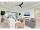 Open living area with comfortable seating, water views, and a sleek ceiling fan at 15525 Corona Del Mar Dr, Wimauma, FL 33598