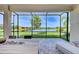 The screened-in patio overlooks the lake, providing a serene view through large glass windows at 15525 Corona Del Mar Dr, Wimauma, FL 33598