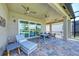 A covered patio featuring brick flooring, ceiling fans, and outdoor furniture, with views of the lake at 15525 Corona Del Mar Dr, Wimauma, FL 33598