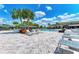 Expansive pool area featuring lounge chairs, shaded cabanas, and lush tropical landscaping at 15525 Corona Del Mar Dr, Wimauma, FL 33598