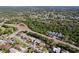 A high altitude aerial shot shows a residential neighborhood with mature trees at 1599 Mcauliffe Ln, Palm Harbor, FL 34683