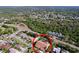 An aerial view shows the house with a screened in pool and patio and fenced yard at 1599 Mcauliffe Ln, Palm Harbor, FL 34683