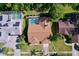 An aerial view shows the house with a screened in pool and patio and fenced yard at 1599 Mcauliffe Ln, Palm Harbor, FL 34683