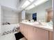 Well-lit bathroom with a double vanity, a large mirror, and a separate tub and shower at 1599 Mcauliffe Ln, Palm Harbor, FL 34683