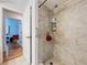 Modern bathroom with a tiled shower and an open doorway to another room at 1599 Mcauliffe Ln, Palm Harbor, FL 34683