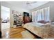 Bright bedroom with wood floors, ceiling fan, and an open door to the playroom at 1599 Mcauliffe Ln, Palm Harbor, FL 34683
