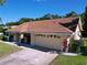 Well-maintained single-story home with a 2 car garage, mature landscaping, and a driveway at 1599 Mcauliffe Ln, Palm Harbor, FL 34683