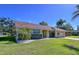 Beautiful one-story home with a well-manicured front lawn and tropical landscaping at 1599 Mcauliffe Ln, Palm Harbor, FL 34683