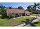 Charming single-story home featuring a well-maintained lawn, mature landscaping and a two-car garage at 1599 Mcauliffe Ln, Palm Harbor, FL 34683