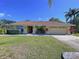 Inviting single-story home with a well-kept lawn and lush landscaping at 1599 Mcauliffe Ln, Palm Harbor, FL 34683