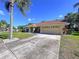 Inviting single-story home featuring a spacious driveway and lush, green lawn at 1599 Mcauliffe Ln, Palm Harbor, FL 34683
