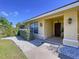 Close up of a charming front porch with decorative lights and a beautiful wooden door at 1599 Mcauliffe Ln, Palm Harbor, FL 34683