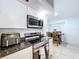 Well-lit kitchen featuring stainless steel appliances, dark countertops and white cabinets at 1599 Mcauliffe Ln, Palm Harbor, FL 34683