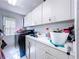 Organized laundry room with ample storage cabinets, sink, and modern appliances at 1599 Mcauliffe Ln, Palm Harbor, FL 34683