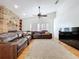 Spacious living room with a brick fireplace, large sectional sofa, and neutral-toned rug at 1599 Mcauliffe Ln, Palm Harbor, FL 34683