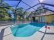 Sparkling screened-in pool with blue water and sunny patio at 1599 Mcauliffe Ln, Palm Harbor, FL 34683