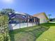 Exterior showing screened-in pool and covered patio with nice lawn at 1599 Mcauliffe Ln, Palm Harbor, FL 34683
