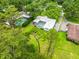 Aerial view of a home featuring a screened pool and lush landscaping in a serene setting at 1675 Robin Hood Ln, Clearwater, FL 33764
