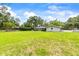 Spacious backyard featuring lush green lawn and a screened-in lanai, ideal for enjoying the outdoors at 1675 Robin Hood Ln, Clearwater, FL 33764