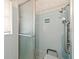Tiled bathroom featuring blue square tiling and a walk-in shower with a seating area and hand rails at 1675 Robin Hood Ln, Clearwater, FL 33764