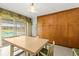 Dining room featuring a wooden table with seating for six and sliding glass doors to the backyard at 1675 Robin Hood Ln, Clearwater, FL 33764