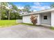 Charming one-story home featuring a concrete driveway, a well-maintained lawn, and lush landscaping at 1675 Robin Hood Ln, Clearwater, FL 33764