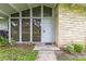 Inviting front entrance with a stone accent wall and large windows with wood blinds at 1675 Robin Hood Ln, Clearwater, FL 33764