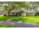 Charming single-story home with stone accents, mature trees, and a well-manicured lawn at 1675 Robin Hood Ln, Clearwater, FL 33764