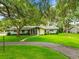 Charming single-story home with stone accents, mature trees, and a well-manicured lawn at 1675 Robin Hood Ln, Clearwater, FL 33764