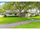 Charming single-story home with stone accents, mature trees, and a well-manicured lawn at 1675 Robin Hood Ln, Clearwater, FL 33764