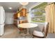 Eat-in kitchen featuring wood cabinets, laminate countertops, vintage appliances, patterned wallpaper, and a view at 1675 Robin Hood Ln, Clearwater, FL 33764