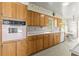 Bright eat-in kitchen featuring wood cabinets, laminate countertops, vintage appliances, and patterned wallpaper at 1675 Robin Hood Ln, Clearwater, FL 33764