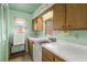 Cozy kitchen featuring retro cabinetry and an adjacent pantry area at 1675 Robin Hood Ln, Clearwater, FL 33764