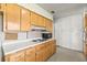 Kitchen featuring wood cabinets, laminate countertops, vintage appliances, and patterned wallpaper at 1675 Robin Hood Ln, Clearwater, FL 33764
