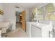 Laundry room featuring a washer and dryer and a view of the kitchen and the outdoors at 1675 Robin Hood Ln, Clearwater, FL 33764