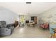 Spacious living room featuring a stone fireplace, unique wall decor, and terrazzo flooring at 1675 Robin Hood Ln, Clearwater, FL 33764
