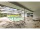 A covered patio with a private screened in-ground pool and a view of a grassy area at 1675 Robin Hood Ln, Clearwater, FL 33764