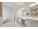 Modern bathroom features dual sinks, large mirrors, a soaking tub, and a shower at 174 Hidden Estates Ct, Brandon, FL 33511