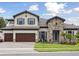 Charming two-story home featuring a stone facade, three-car garage, and well-manicured lawn at 174 Hidden Estates Ct, Brandon, FL 33511