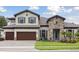 Charming two-story home featuring a three-car garage, stone accents, and a well-manicured lawn at 174 Hidden Estates Ct, Brandon, FL 33511