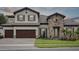 Two-story home with beautiful stone accents, wood garage door, and manicured front yard at 174 Hidden Estates Ct, Brandon, FL 33511
