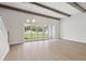 A bright, airy living room with wood beams, a chandelier, and a large sliding glass door overlooking the backyard at 174 Hidden Estates Ct, Brandon, FL 33511
