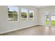 Bright living room featuring wood floors, three large windows and doors to outside at 174 Hidden Estates Ct, Brandon, FL 33511