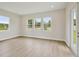Bright living room featuring wood floors, three large windows and doors to outside at 174 Hidden Estates Ct, Brandon, FL 33511