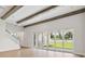 An open-concept living room with wooden beams, and sliding glass doors that lead to the backyard at 174 Hidden Estates Ct, Brandon, FL 33511