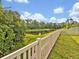 Scenic backyard view featuring a white fence, pond, and lush greenery creating a private oasis at 17845 Cortes Creek Blvd, Spring Hill, FL 34610