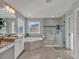 Modern bathroom featuring double sinks, a soaking tub, and a glass-enclosed shower at 17845 Cortes Creek Blvd, Spring Hill, FL 34610